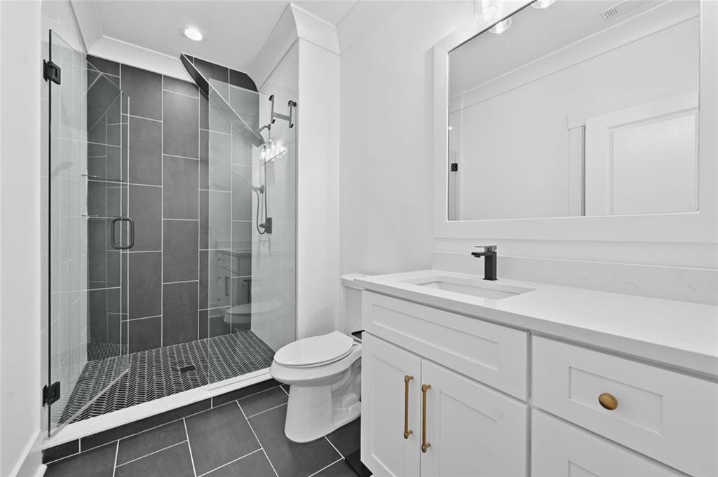 2694 Thompson Mill Road Buford, GA 30519 - Photo 52 of 70 a bathroom with a shower sink vanity and toilet