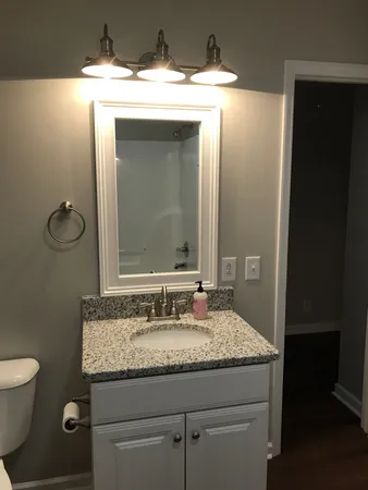 a bathroom with a granite countertop sink and a mirror