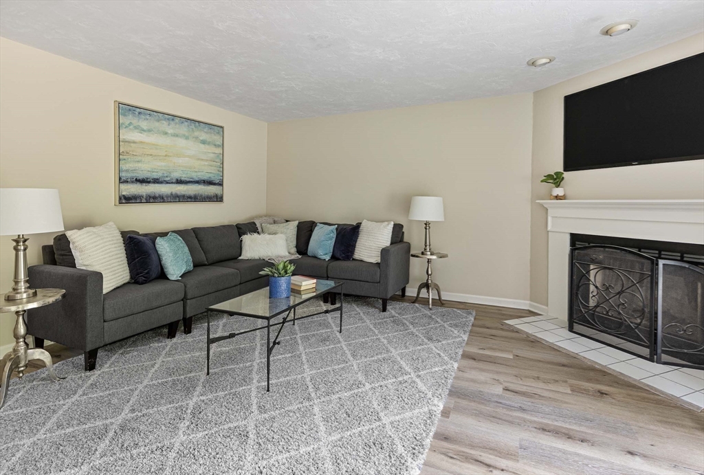 21 Midgley Lane Worcester, MA 01604 - Photo 15 of 25 a living room with furniture a flat screen tv and a fireplace