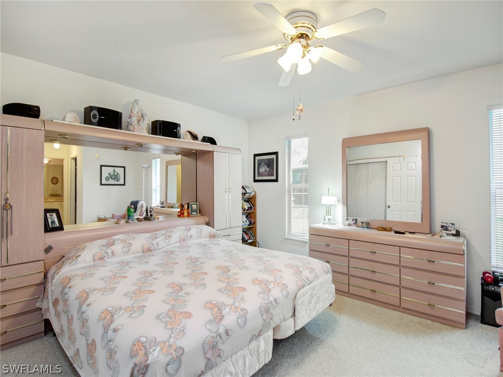 18205 Apple Road Fort Myers, FL 33967 - Photo 11 of 25 a spacious bedroom with a large bed and a chandelier