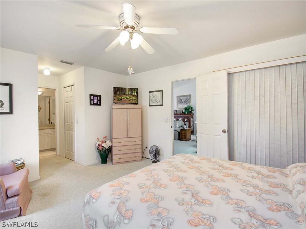 18205 Apple Road Fort Myers, FL 33967 - Photo 12 of 25 a bedroom with a bed and a chandelier