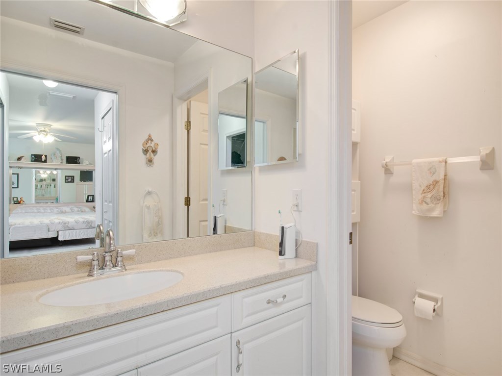 18205 Apple Road Fort Myers, FL 33967 - Photo 14 of 25 a bathroom with a granite countertop sink mirror vanity and toilet