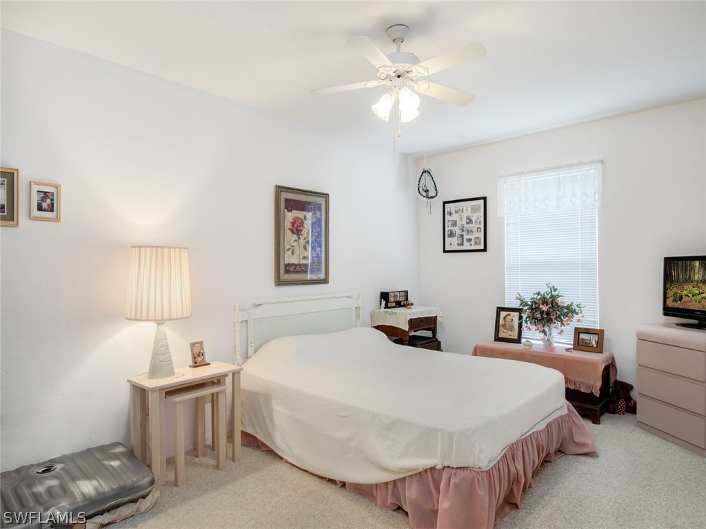 18205 Apple Road Fort Myers, FL 33967 - Photo 15 of 25 a bedroom with a bed and a chandelier
