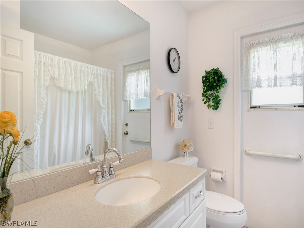 18205 Apple Road Fort Myers, FL 33967 - Photo 17 of 25 a bathroom with a granite countertop sink mirror vanity and toilet