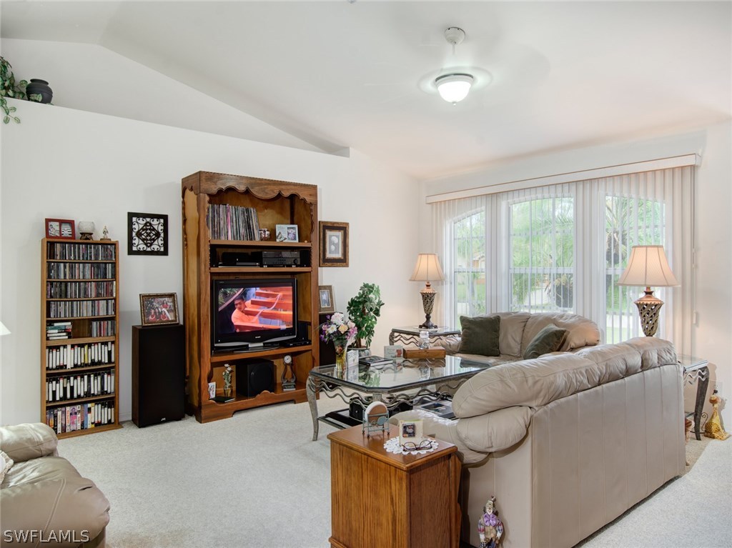 18205 Apple Road Fort Myers, FL 33967 - Photo 3 of 25 a living room with furniture a floor to ceiling window and a flat screen tv