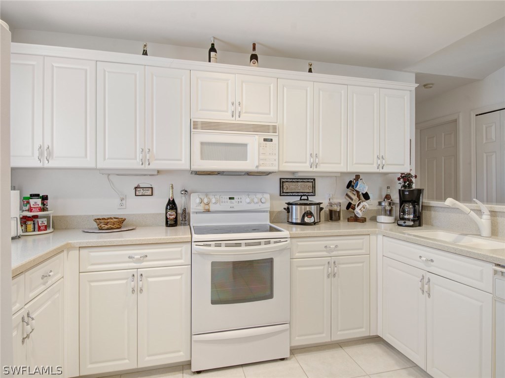 18205 Apple Road Fort Myers, FL 33967 - Photo 8 of 25 a kitchen with white cabinets and white appliances