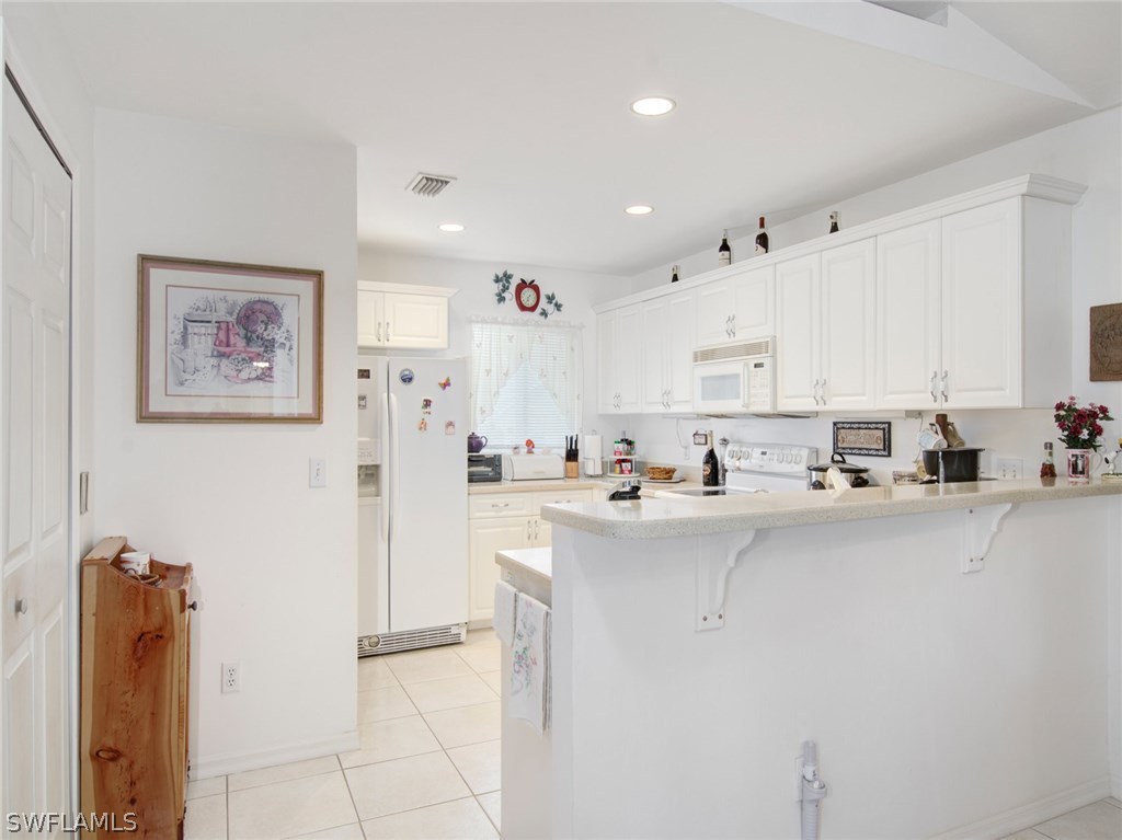 18205 Apple Road Fort Myers, FL 33967 - Photo 9 of 25 a kitchen with stainless steel appliances a refrigerator sink and cabinets