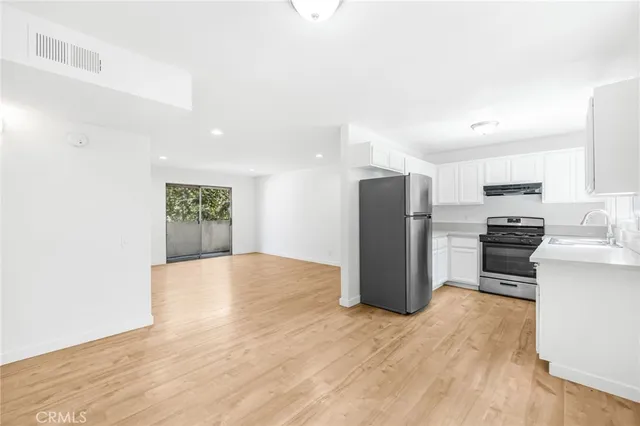 a view of kitchen view with refrigerator stove and wooden cabinets