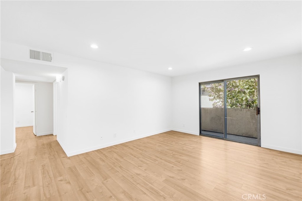 11151 Arminta Street, Unit 201A Sun Valley, CA 91352 - Photo 6 of 14 a view of an empty room with wooden floor and a window