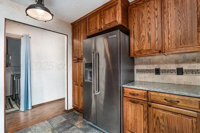 a kitchen with stainless steel appliances granite countertop a refrigerator and a sink
