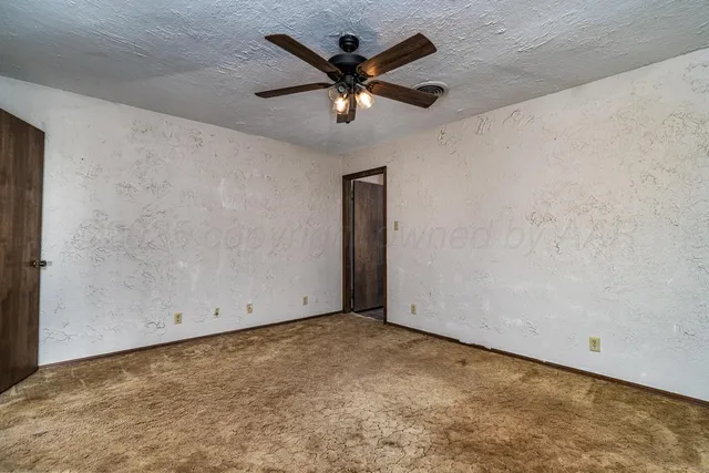 an empty room with closet and ceiling fan