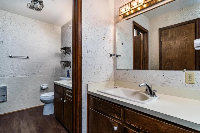 a bathroom with a sink a toilet a shower and a mirror