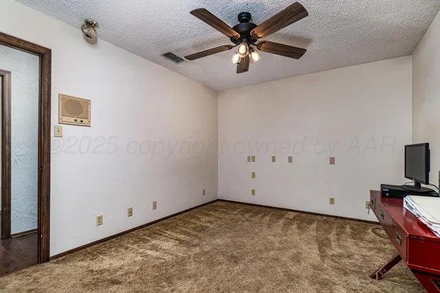 a view of a big room with wooden floor and a ceiling fan