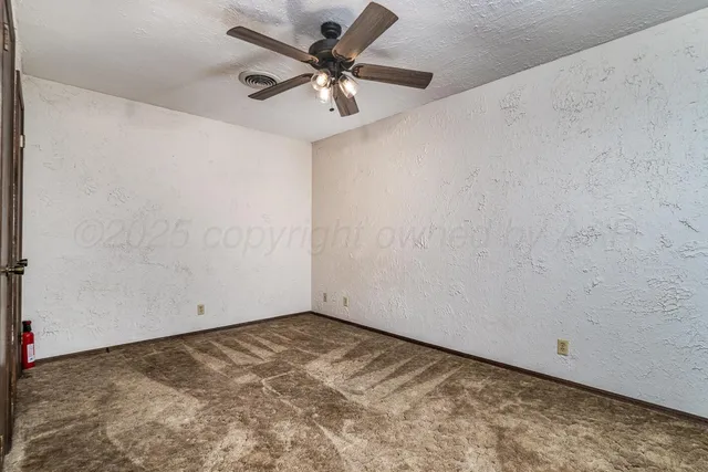 an empty room with a ceiling fan and wooden floor