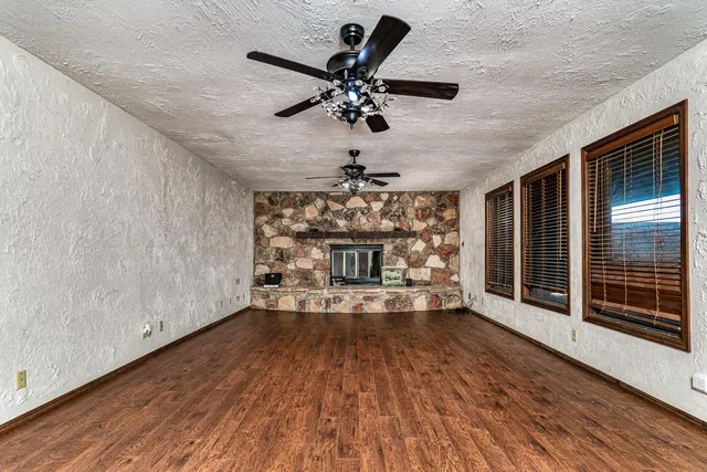 a view of a livingroom with a fireplace a chandelier and wooden floor