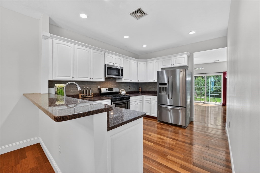 15 Evergreen Circle, Unit 15 Canton, MA 02021 - Photo 9 of 29 a kitchen with granite countertop stainless steel appliances a refrigerator a stove top oven a sink and cabinets