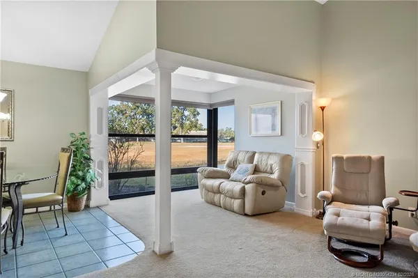 a living room with furniture and a floor to ceiling window
