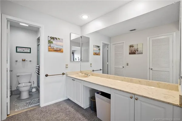 a spacious bathroom with a granite countertop sink toilet and shower