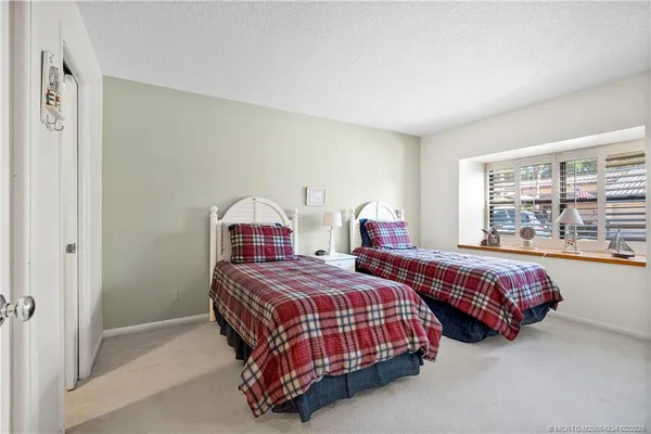 a bedroom with two beds and window