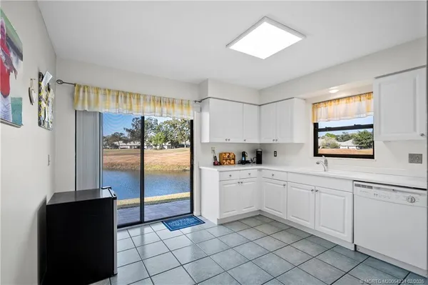 a kitchen with white cabinets and a refrigerator