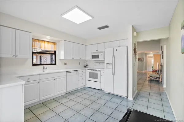 a kitchen with white cabinets and white appliances