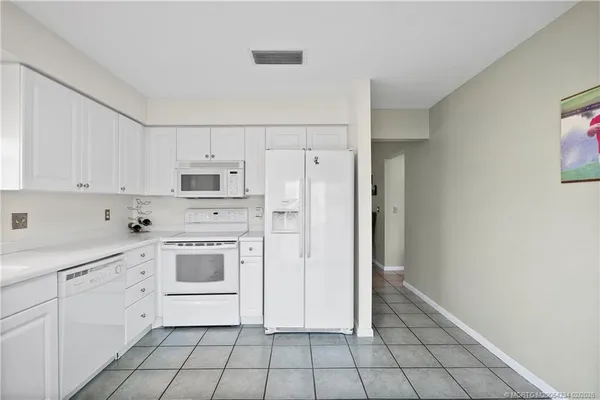 a kitchen with white cabinets and white appliances