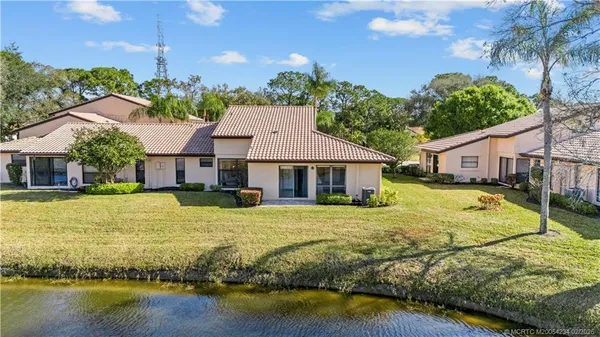 a view of a house with pool and sitting area