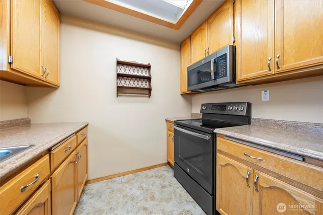 a kitchen with granite countertop a sink and a refrigerator