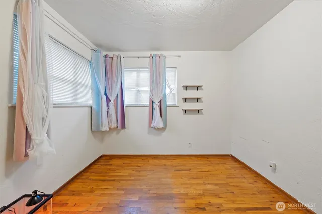 a view of a room with wooden floor and windows