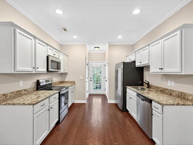 a kitchen with a stove a sink a microwave a refrigerator and cabinets