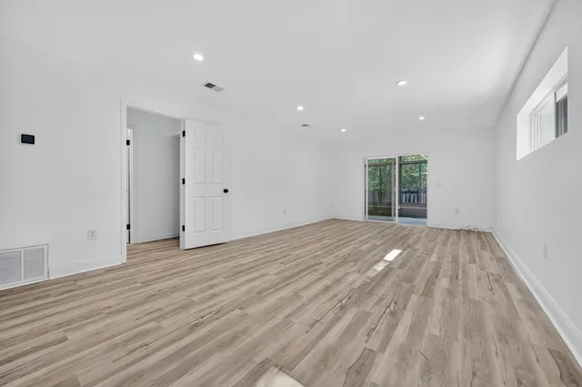a view of empty room with wooden floor