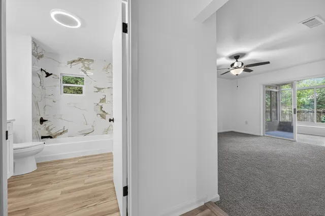 an empty room with a window and a ceiling fan