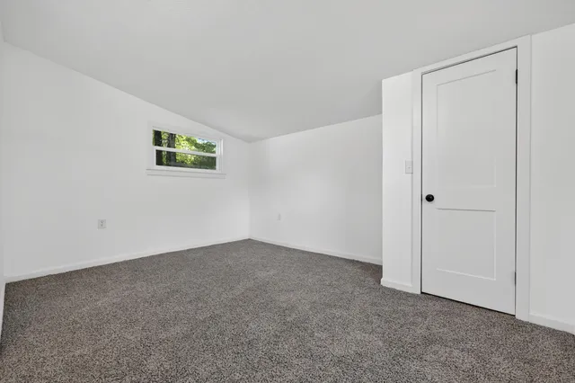 an empty room with chandelier fan