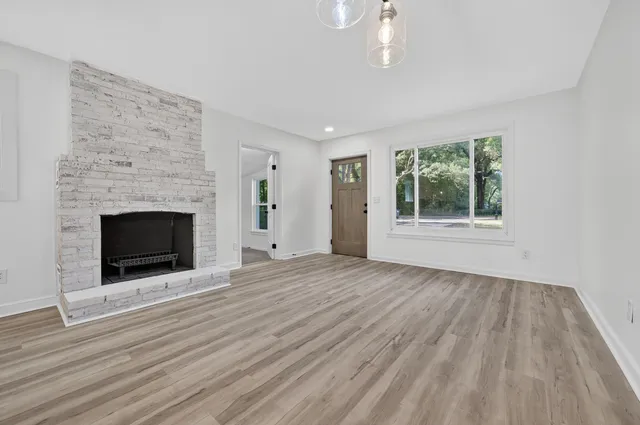 a large kitchen with kitchen island a stove a sink dishwasher and a fireplace with wooden floor