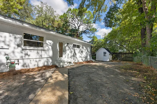 a view of swimming pool with outdoor seating and trees in the background