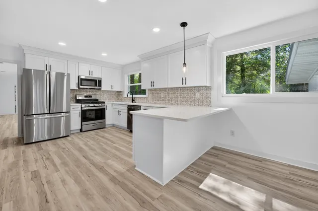 a kitchen with granite countertop a refrigerator stove and microwave