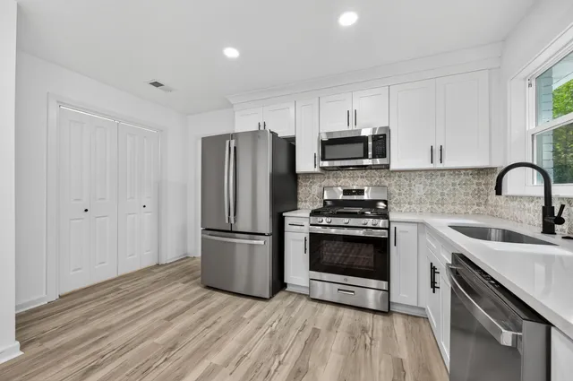 a kitchen with stainless steel appliances granite countertop a sink stove and microwave