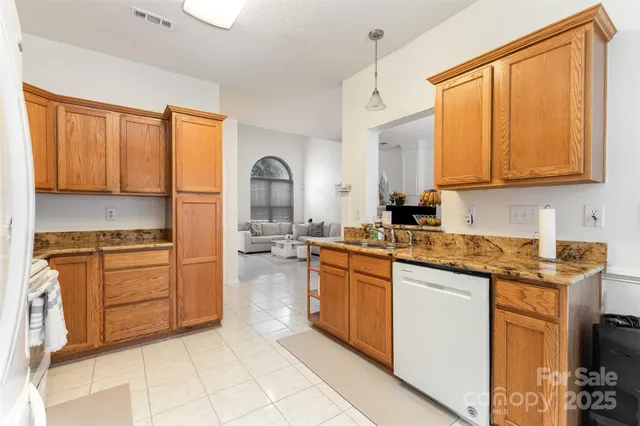 a kitchen with stainless steel appliances granite countertop a stove sink and cabinets
