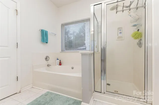 a white bath tub sitting next to a white sink and a glass door