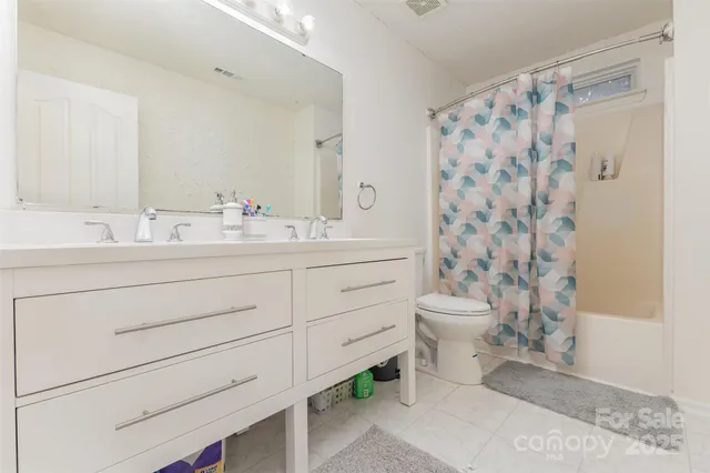 a bathroom with a double vanity sink toilet and shower
