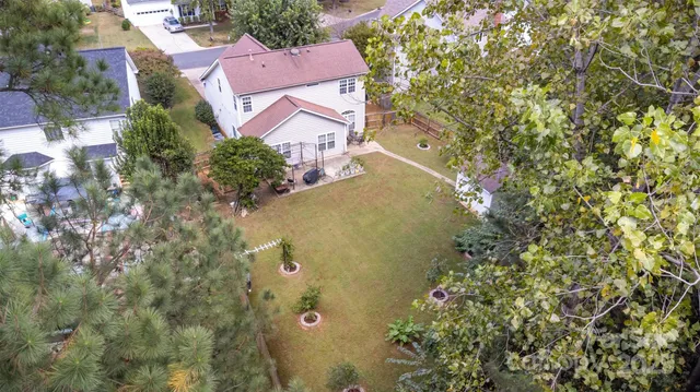 an aerial view of residential houses with outdoor space and trees
