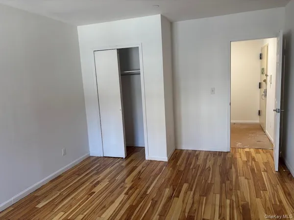 a view of a room with wooden floor and a bathroom