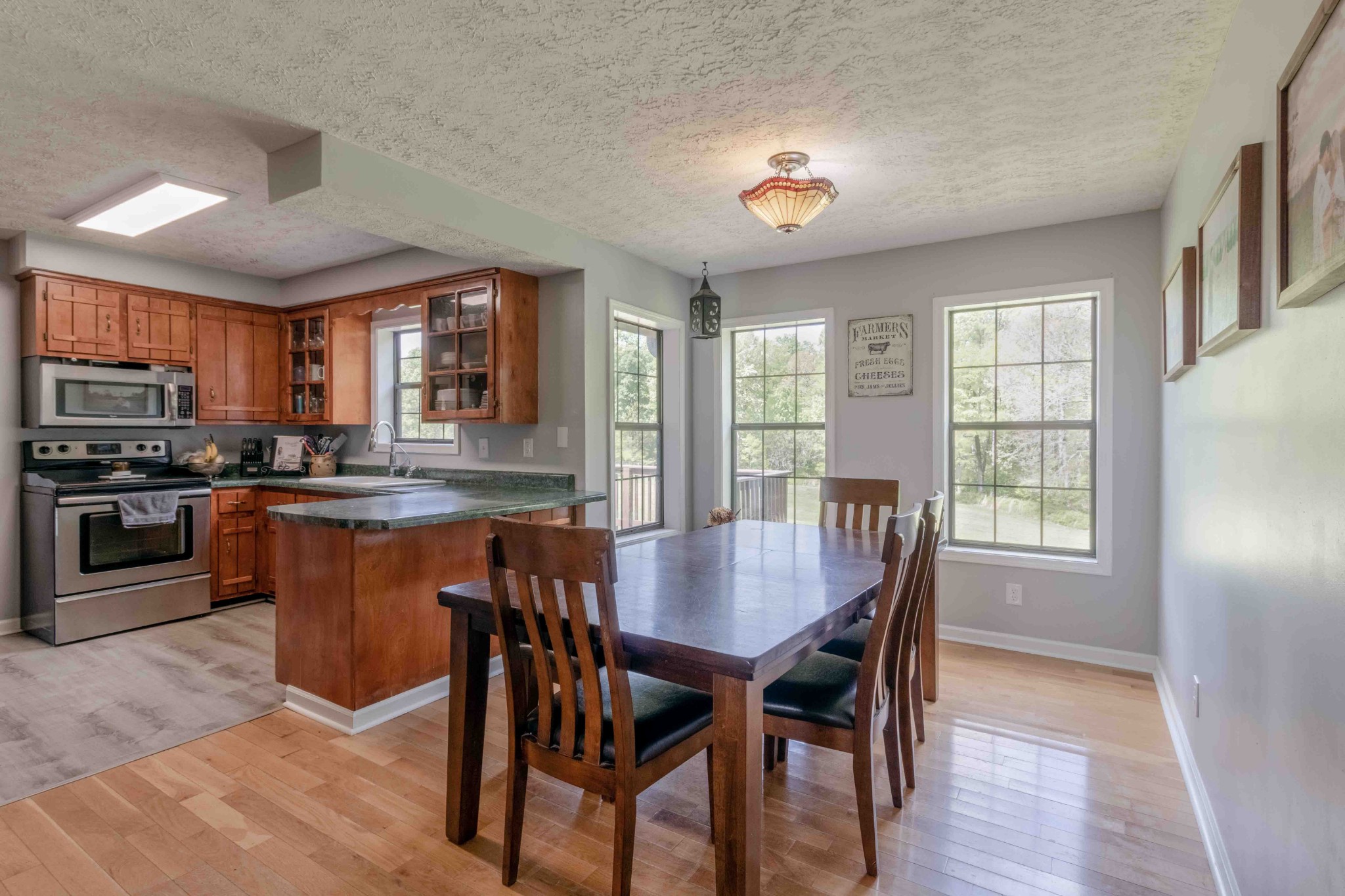 946 Hayes Ridge Road Indian Mound, TN 37079 - Photo 9 of 23 a kitchen with stainless steel appliances granite countertop a stove top oven a sink dishwasher a dining table and chairs with wooden floor
