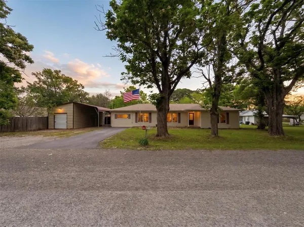 a front view of a house with a yard and trees