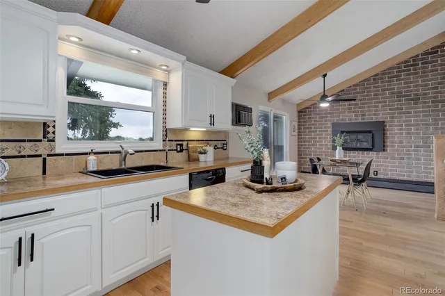 a kitchen with kitchen island granite countertop a sink appliances and cabinets