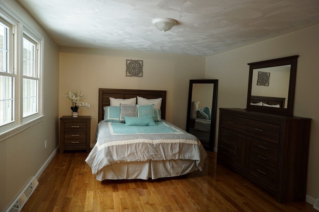 38 Blanchard Road Wilmington, MA 01887 - Photo 13 of 21 a bedroom with a bed and wooden floor