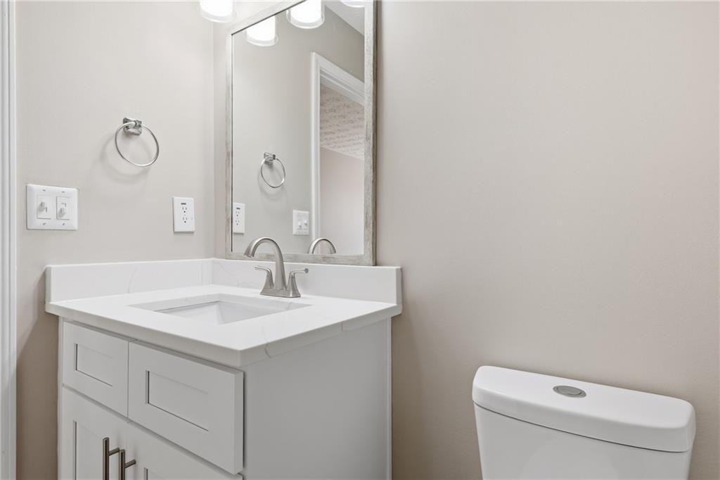 3570 Bogan Mill Road Northeast Buford, GA 30519 - Photo 22 of 31 a bathroom with a sink a toilet and a mirror