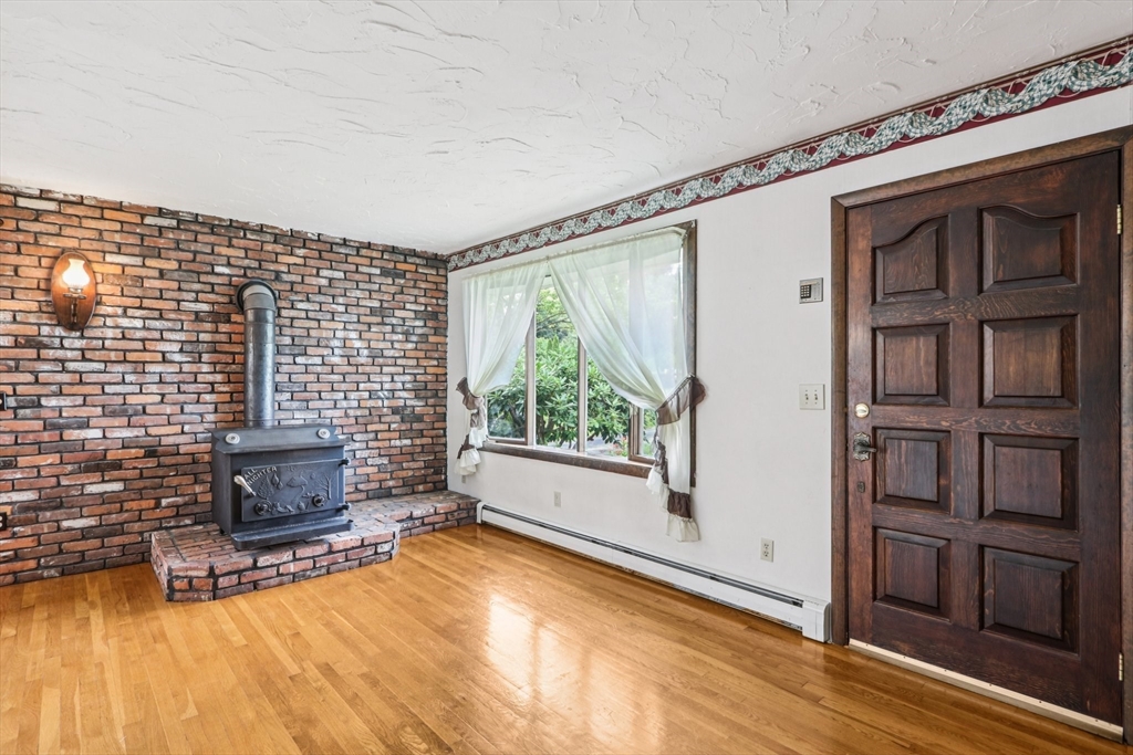 16 Indian Run Road Bellingham, MA 02019 - Photo 6 of 34 a living room with furniture wooden floor and a fireplace