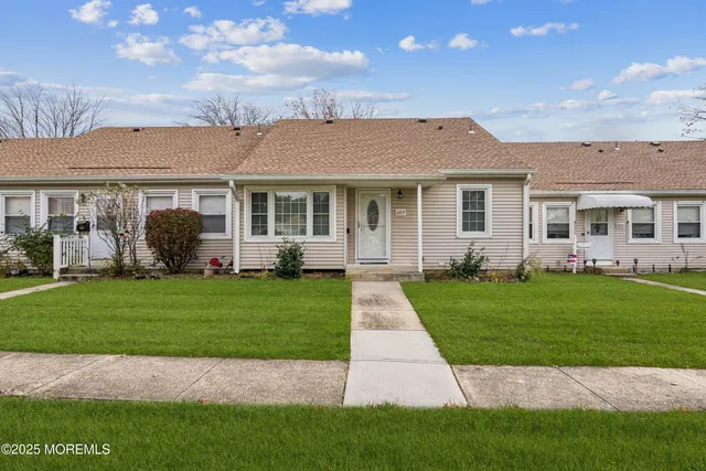 a front view of a house with a garden and yard