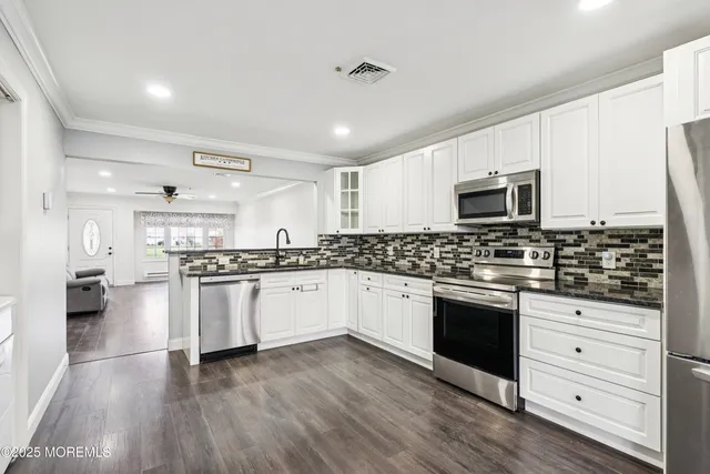 a kitchen with granite countertop a stove top oven a sink dishwasher and a refrigerator